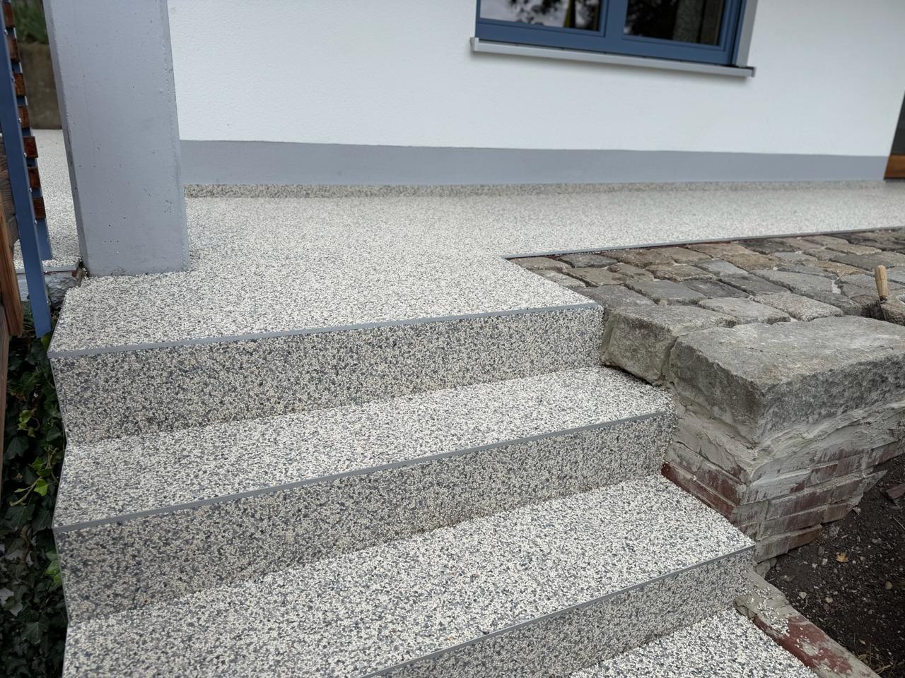 Hauseingang mit Steinteppich-Stufen in Hellgrau