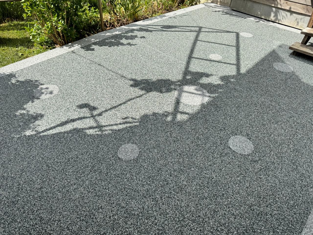 Terrasse mit Steinteppich in Graugrün im Garten